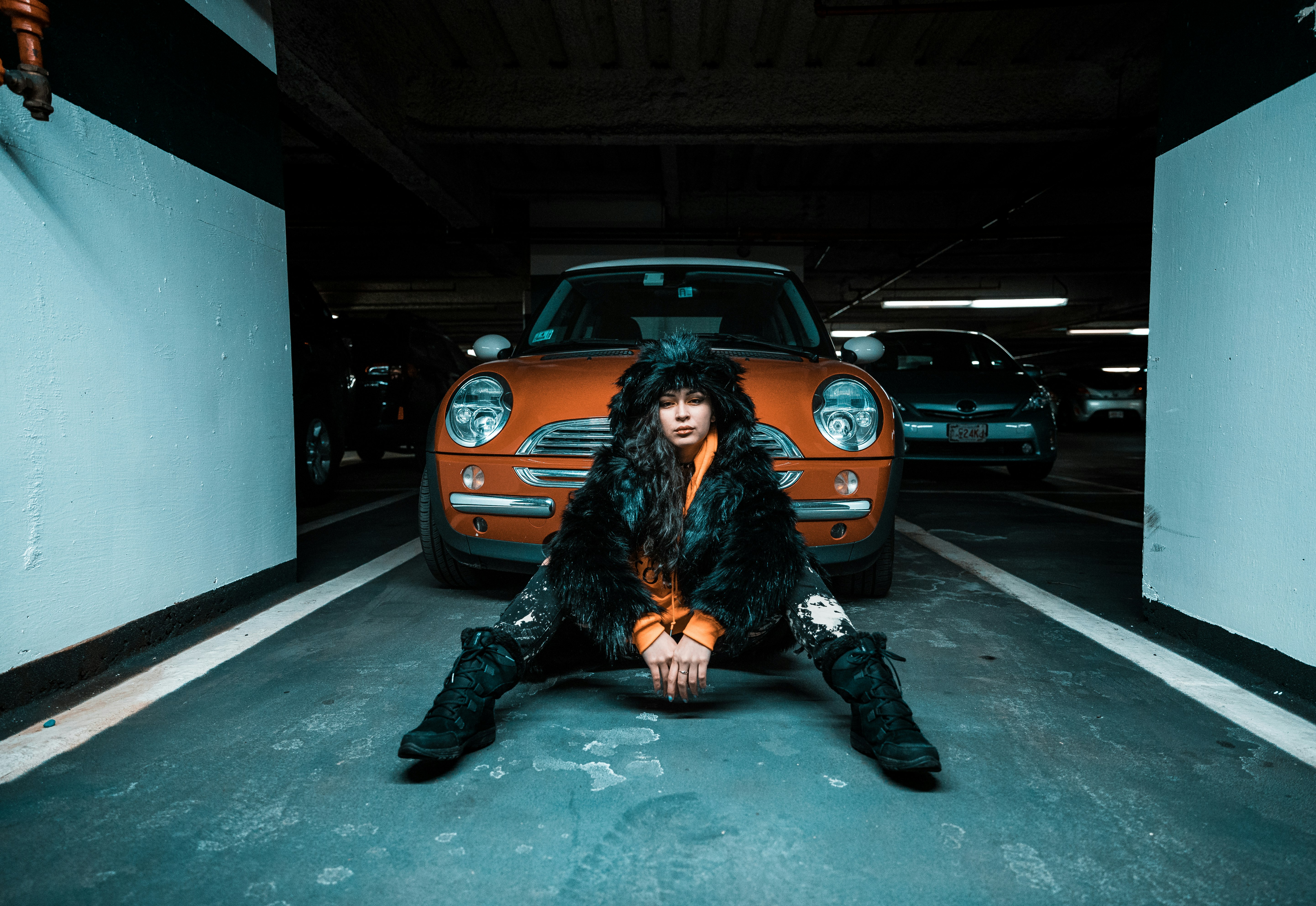 woman sitting on pavement near car